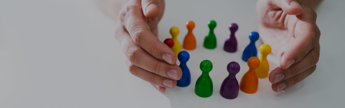 Immagine raffigurante due mani che attorniano degli scacchi colorati 
